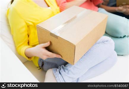 transportation, mail, delivery, shipping and people concept - close up of teenage girls with cardboard box at home