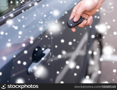 transportation, people, season and ownership concept - close up of man with car key outdoors