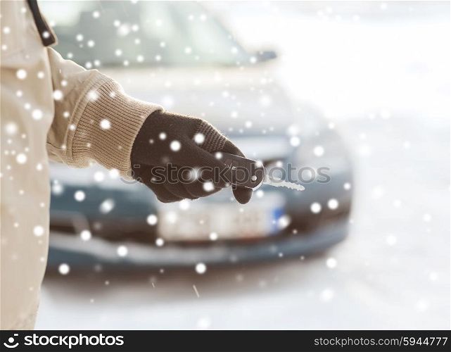 transportation, people, season and ownership concept - close up of man with car key outdoors