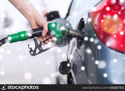 transportation, tanking, people and vehicle concept - close up of male hand with fuel hose nozzle tanking car