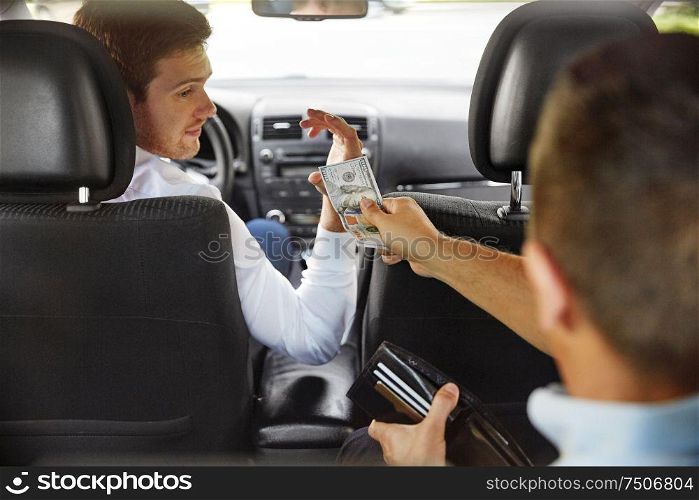 transportation, taxi and payment concept - male car driver looking at passenger with money in wallet. male car driver looking at passenger with money