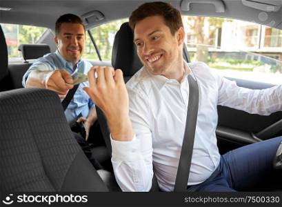 transportation, taxi and payment concept - male car driver taking money from passenger. male car driver taking money from passenger