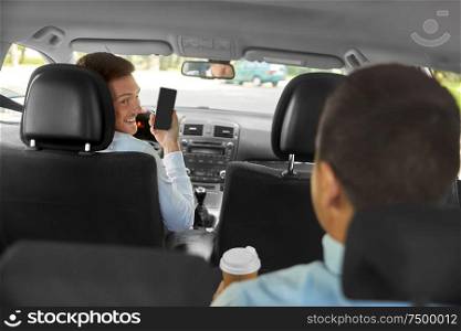 transportation, taxi and technology concept - smiling car driver showing smartphone to male passenger. car driver showing smartphone to male passenger
