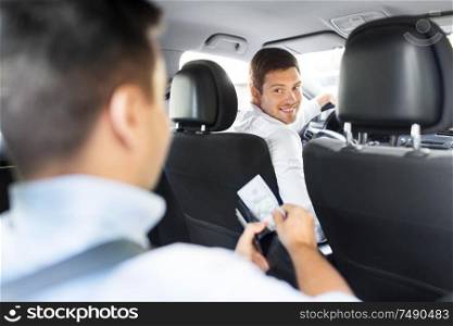 transportation, vehicle and payment concept - male car driver looking at passenger with money in wallet. male car driver looking at passenger with money