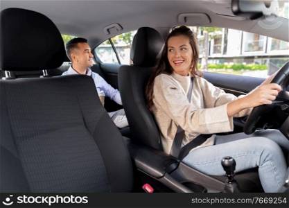 transportation, vehicle and people concept - happy smiling female driver driving car with male passenger. female driver driving car with male passenger