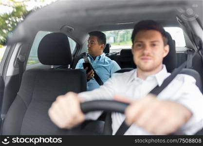 transportation, vehicle and people concept - middle aged male passenger with smartphone on back seat and car driver. male passenger with smartphone and car driver