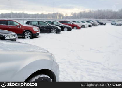 transportation, winter and vehicle concept - car parking with snow