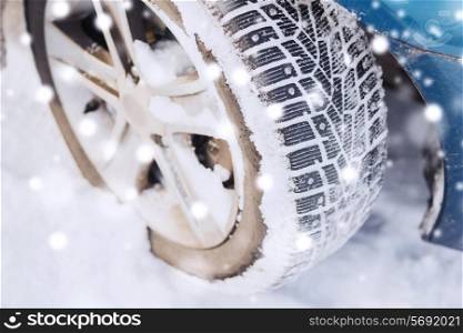 transportation, winter and vehicle concept - closeup of car wheel