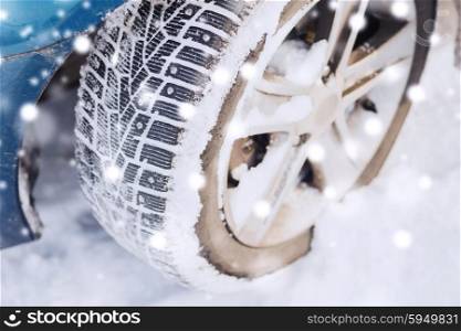 transportation, winter and vehicle concept - closeup of car wheel