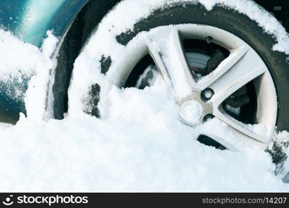 transportation, winter and vehicle concept - closeup of car wheel stuck in snow