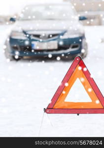 transportation, winter and vehicle concept - closeup of warning triangle and car