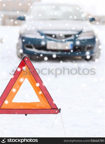 transportation, winter and vehicle concept - closeup of warning triangle and car