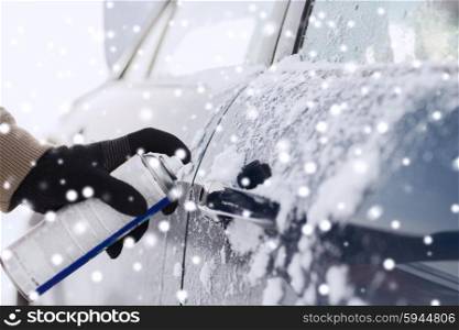 transportation, winter, people and vehicle concept - closeup of man hand with lock door de-icer
