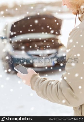 transportation, winter, people and vehicle concept - closeup of man with broken car and cell phone