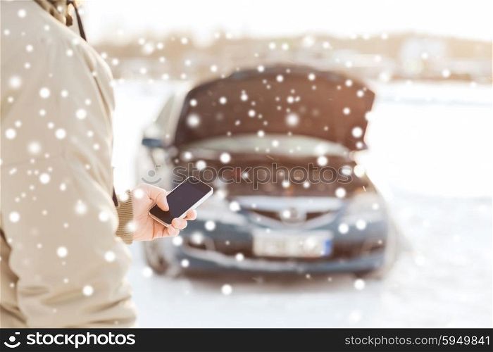 transportation, winter, people and vehicle concept - closeup of man with broken car and cell phone