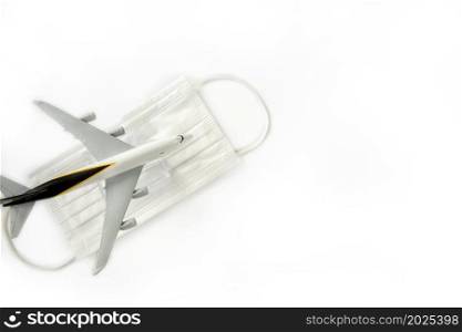 Travel and health concept during covid-19 pandemic. passenger airplane and white masks isolated on white background, travel,coronavirus concept with copy space space for text. Travel and health concept during covid-19 pandemic. passenger airplane and white masks isolated on white background, travel,coronavirus concept with copy space