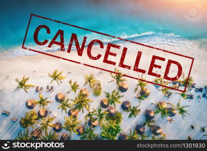 Travel and holidays cancelled due to epidemic of coronavirus. Tourism and resort cancelation due to Covid-19. Aerial view of beautiful tropical sandy beach, palm trees, blue sea in summer and text