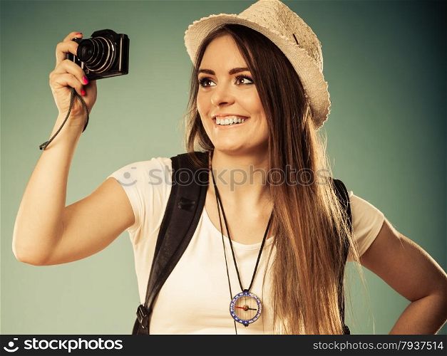 Travel and tourism active lifestyle concept. Tourist woman with backpack taking photo with camera vintage toned