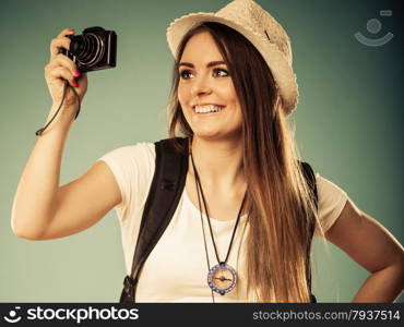 Travel and tourism active lifestyle concept. Tourist woman with backpack taking photo with camera vintage toned