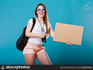 Travel and tourism active lifestyle concept. Woman tourist hitchhiking with blank sign for text on blue