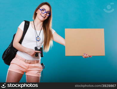 Travel and tourism active lifestyle concept. Woman tourist hitchhiking with blank sign for text on blue