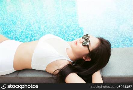 travel and vacation concept - close up of young woman rest relaxing at a pool in summer
