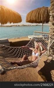 Travel and vacation concept - Woman relaxing on hammock on the beach.. Travel and vacation concept - Woman relaxing on hammock on the beach
