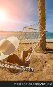 Travel and vacation concept - Woman relaxing on hammock on the beach.. Travel and vacation concept - Woman relaxing on hammock on the beach