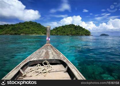 travel background head of wooden boat on transparent blue sea at snorkeling spot in surin islands national park, thailand