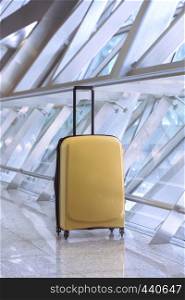 travel - beautiful yellow suitcase stands in the airport corridor