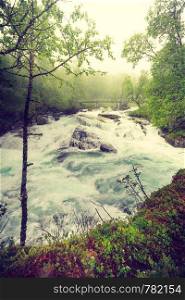 Travel, beauty in nature. Small bridge and waterfall torrential river along the Aurlandsfjellet mountains in Norway Sogn og Fjordane, foggy hazy summer day. Waterfall along the Aurlandsfjellet Norway