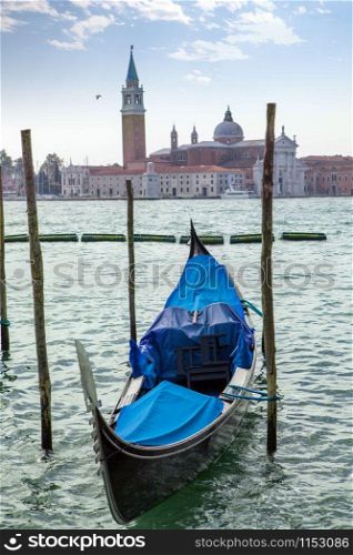 Travel boat italian gondola parking on the water on the background of San Giorgio Maggiore in Venice, Italia.. Italian gondola parking on the water in Venice, Italia.