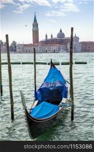 Travel boat italian gondola parking on the water on the background of San Giorgio Maggiore in Venice, Italia.. Italian gondola parking on the water in Venice, Italia.