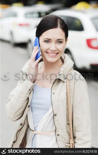 travel, business trip, people and tourism concept - smiling young woman calling and talking on smartphone over taxi station or city street