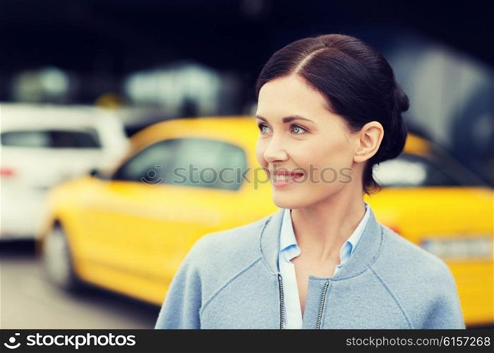 travel, business trip, people and tourism concept - smiling young woman over taxi station or city street