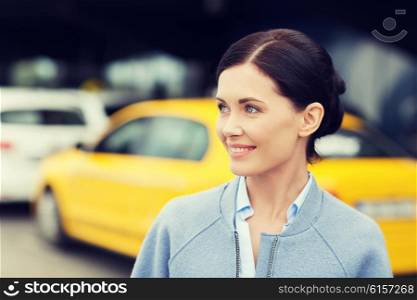 travel, business trip, people and tourism concept - smiling young woman over taxi station or city street