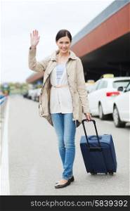 travel, business trip, people and tourism concept - smiling young woman with travel bag over taxi at airport terminal or railway station