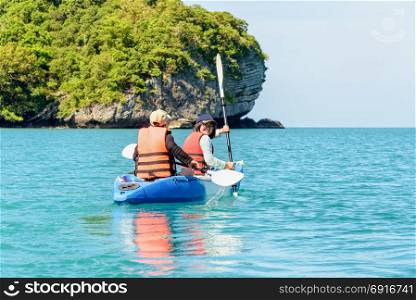 Travel by boat with a kayak. Two women are mother and daughter. Travel by boat with a kayak happy on the sea under the bright summer sky front of Ko Wua Ta lap islands at Mu Ko Ang Thong National Park, Surat Thani, Thailand