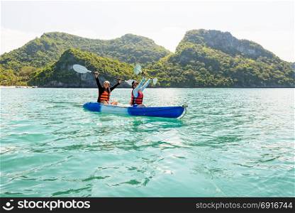 Travel by boat with a kayak. Two women are mother and daughter. Travel by boat with a kayak happy on the sea under the bright summer sky front of Ko Wua Ta lap islands at Mu Ko Ang Thong National Park, Surat Thani, Thailand