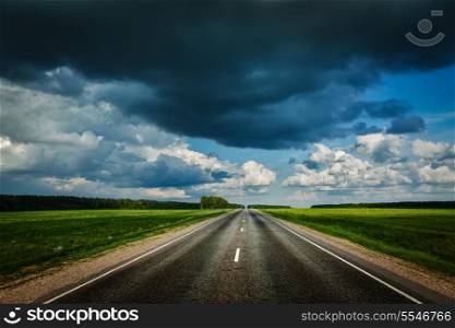 Travel concept background - road and stormy sky