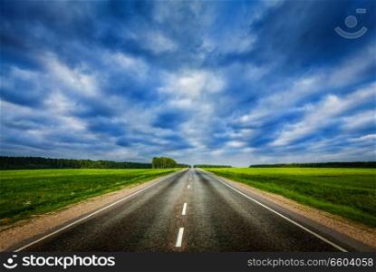 Travel concept background - road under dramatic stormy cloudy sky. Road and stormy sky