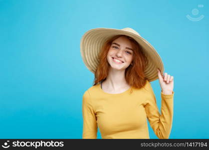 Travel concept - Close up Portrait young beautiful attractive ginger red hair girl with trendy hat and smiling. Blue Pastel Background. Copy space.