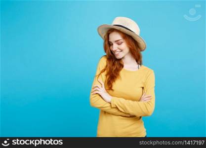 Travel concept - Close up Portrait young beautiful attractive ginger red hair girl with trendy hat and smiling. Blue Pastel Background. Copy space.