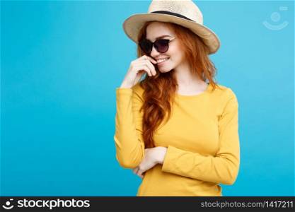 Travel concept - Close up Portrait young beautiful attractive ginger red hair girl with trendy hat and sunglass smiling. Blue Pastel Background. Copy space.