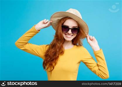 Travel concept - Close up Portrait young beautiful attractive redhair girl with trendy hat and sunglass smiling. Blue Pastel Background. Copy space.