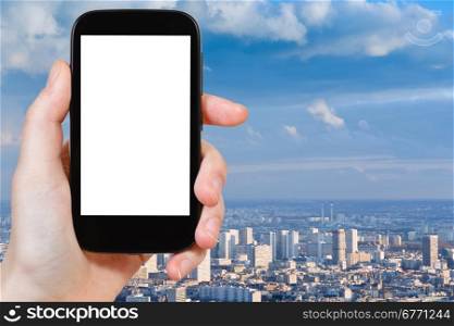 travel concept - hand holds smartphone with cut out screen and Paris panorama on background
