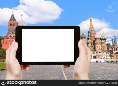 travel concept - hand holds tablet pc with cut out screen and Vasilevsky descent of Red Square with Pokrovsky Cathedral on background