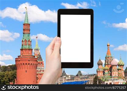 travel concept - hand holds tablet pc with cut out screen and Moscow Kremlin Towers on background