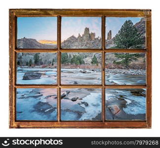 travel concept or a greeting card from Colorado - Poudre River in winter as seen through vintage, grunge, sash window with dirty glass
