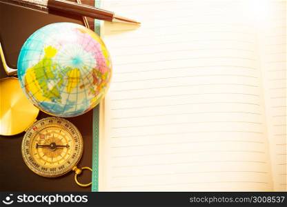 Travel concept, pen, compass, globe and empty of notebook for for blog entries, you can place your text or information. Top view. Vintage filtered.